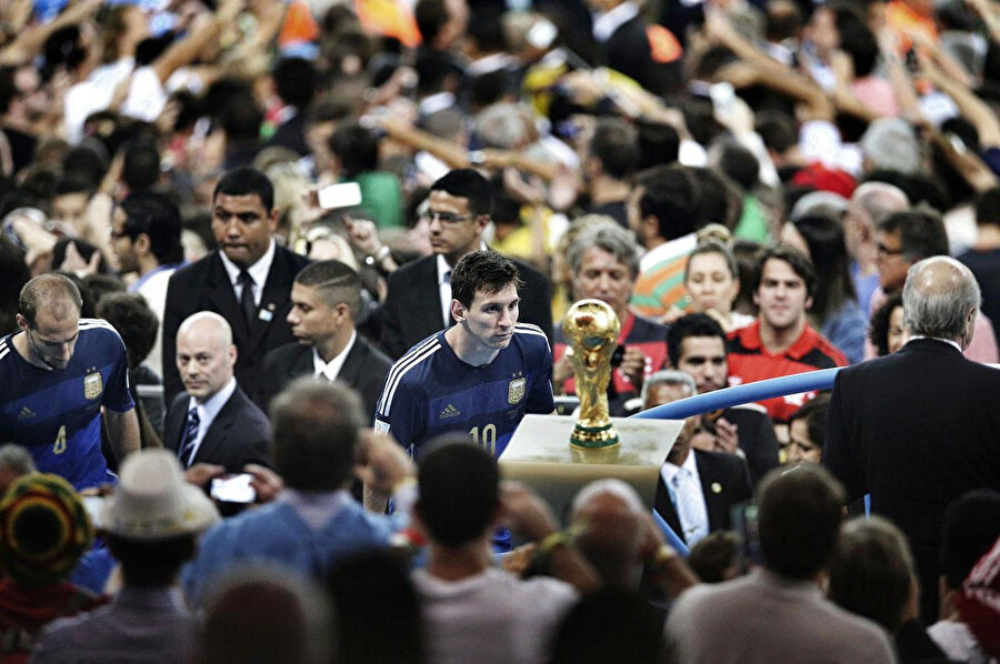 Arjantin’in kaptanı Lionel Messi, 2014 FIFA Dünya Kupası Finali’nde uzatmalarda gelen son dakika golüyle kaybettikleri kupaya bakıyor.
