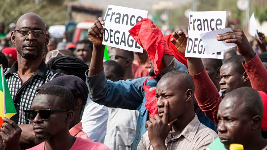 Eylemciler, ellerinde ülkelerinin bayraklarının yanı sıra Rus bayrakları taşıyor ve "Fransa defol" manasına gelen Fransızca "France degage" yazılı dövizler taşıyor.