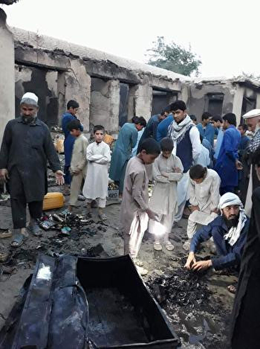 Afgan vatandaşlar, beş kişiyi öldüren Zero Units alt grubu "02" baskınının geride bıraktığı kalıntıları ayıklarken. (Kaynak: Propublica)