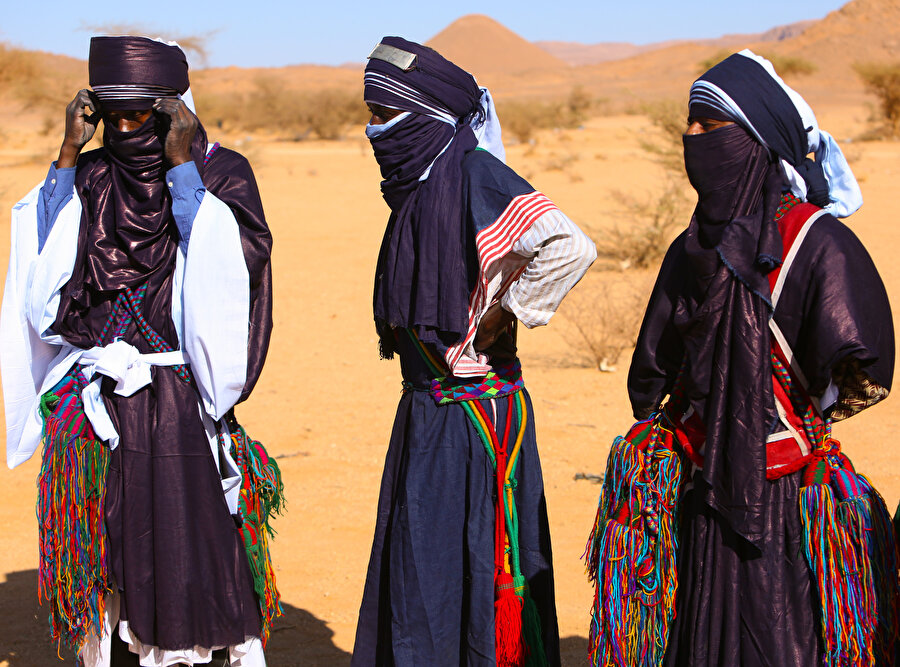 Bir Berberi kabilesi olan Tuaregler, mavi, uzun, bütün bedeni saracak şekilde tasarlanmış kendilerine özgü etnik giysiler giyiyor ve yüzlerini örtüyle kapatıyor.