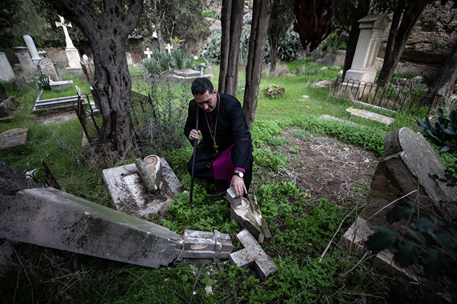 Kudüs Anglikan Başpiskoposu Husam Naum tahrip edilen mezarlığı inceliyor.