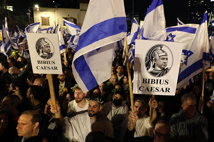 İsrailli protestocular, Netanyahu'nın yeni aşırı sağcı hükûmetine karşı düzenlenen gösteriler sırasında Benjamin Netanyahu'yu Jül Sezar olarak tasvir eden pankartlar taşıyor.