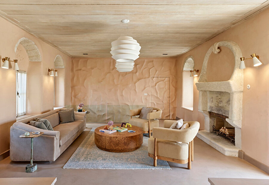  Doğal taş dokuya sahip duvarlar ahşap mobilyalar ile bütünleştiriliyor.