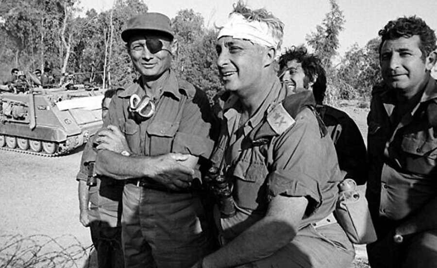 Süveyş Kanalı'nın batı yakasında, bir yaralanmanın ardından başı sargılı Tümgeneral Ariel Şaron, Savunma Bakanı Moşe Dayan'la birlikte duruyor.