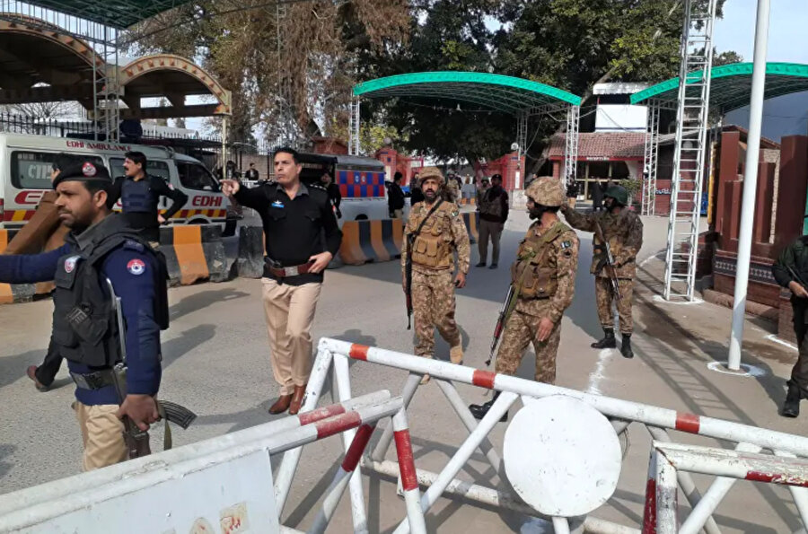 Ordu ve polis personeli, Pakistan'ın Peşaver kentindeki patlama alanına doğru koşan ambulansların önünü açtı.