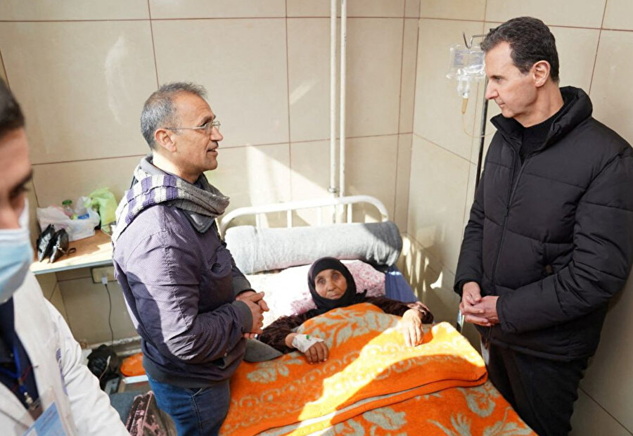 10 Şubat 2023'te Suriye Devlet Başkanı Beşar Esad, Suriye'deki Halep Üniversite Hastanesi'nde yaşlı bir kadını ziyaret ediyor.