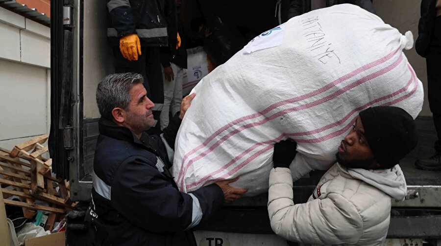 Depremin ardından yardım için seferber olan yabancı öğrenciler, yardım toplama merkezinde bağışların paketlenmesi ve tırlara yüklenmesine yardım ediyor. 