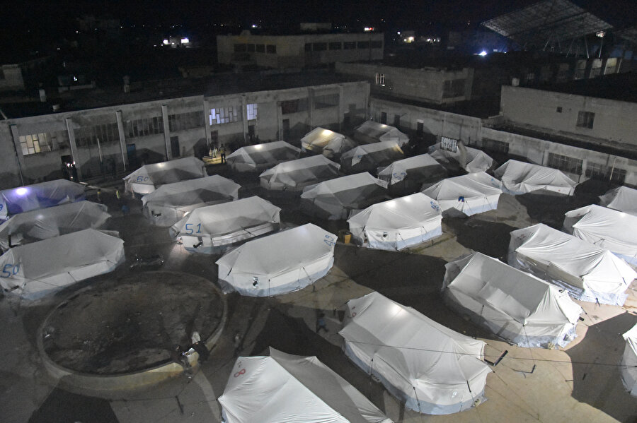 Kahramanmaraş merkezli depremlerden etkilenen Suriye'nin kuzeybatısındaki bölgelerde evleri yıkılan veya zarar gören aileler, bir haftadır okullarda ve okul bahçesinde kurdukları derme çatma çadırlarda yaşıyor.