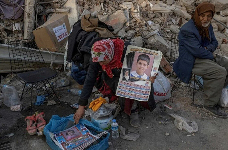 Depremden sonra Hatay'da bir kadın torununun fotoğraflarıyla enkaz başında bekliyor.