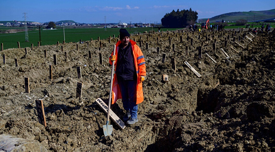 Hatay'da Şubat depremi sonrası belediye çalışanı mezar kazma işinde çalışıyor.
