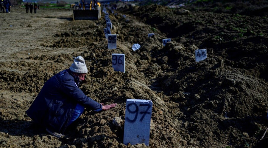 Hatay'da 10 Şubat 2023'te mezar alanında bir adam yas tutuyor.