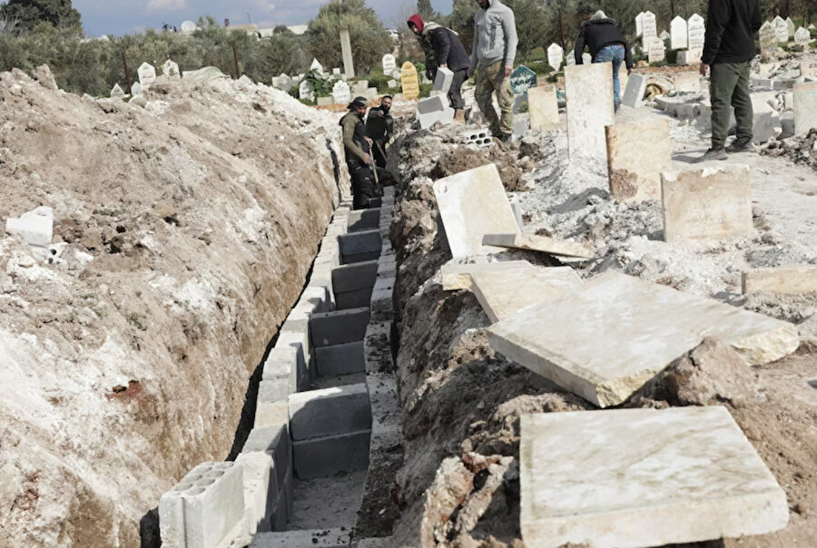 Gönüllüler, Suriye'nin isyancı kontrolündeki Jandaris kasabasında toplu mezarlar hazırlıyor. 