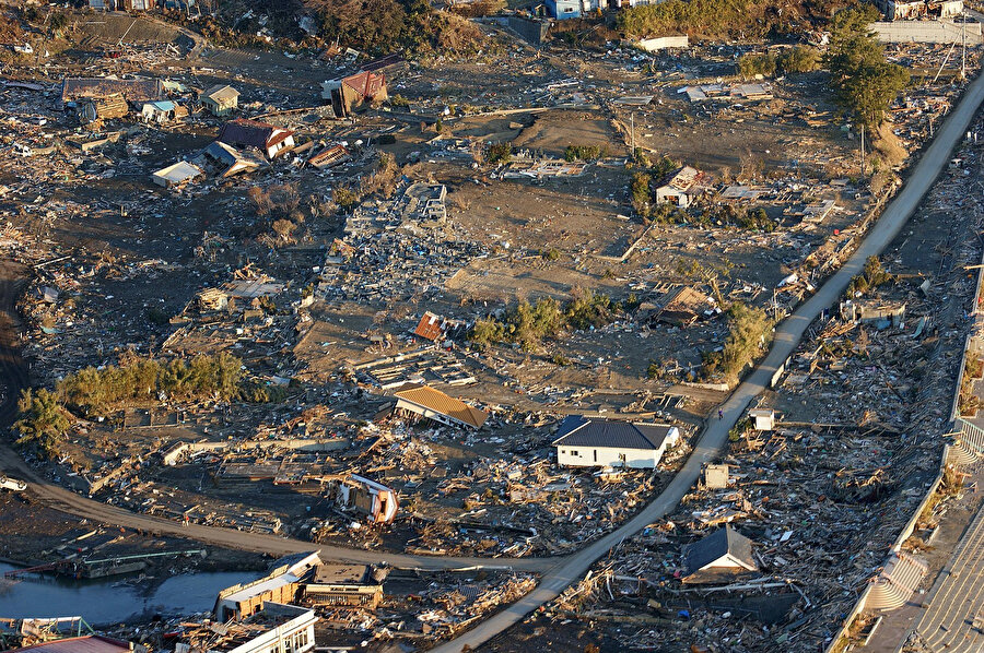 9.0 büyüklüğünde deprem ve ardından gelen tsunaminin bölgeyi harap etmesinden sonra Japonya'nın kuzeyindeki Honshu'daki hasarın havadan görünümü. Fotoğraf: Jay Okonek/ABD Donanması