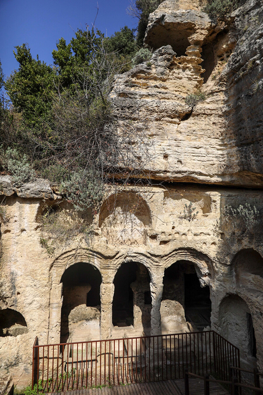 Tünelin deniz tarafındaki girişine göre sağ tarafta 100 metre kadar uzaklıkta bulunan Beşikli Mağara, kaya mezarlarının en geniş ve en ünlülerinden olup, içerisinde bölümler halinde on iki mezar vardır. Mezarlar birbirlerinden duvarlar ile ayrılmıştır. Bu taş mezarlar, taş sütunlar ve kemerlerin birbirine bağladığı bölümler halinde olup, yukarıdan aşağıya yine taş merdivenlerle inilmektedir. 
