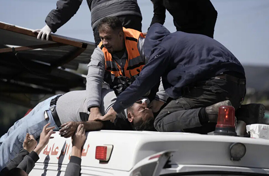 Sağlık görevlileri, İsrail'in işgal altındaki Batı Şeria kentine düzenlediği baskın sonrasında yaralananlara yardım ediyor.