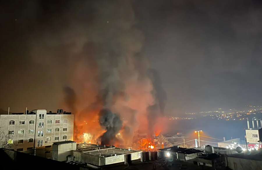 Batı Şeria'nın Hawara kasabasında İsrailli yerleşimcilerin saldırmasının ardından dumanlar ve alevler yükseliyor.