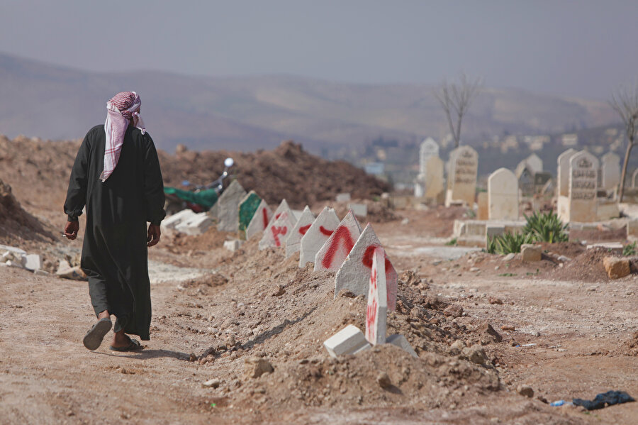 Suriye'de kayıt işlemleri tamamlanan isimsiz naaşlar, sonraki aşamada numaralarla işaretlenmiş mezarlara defnediliyor.