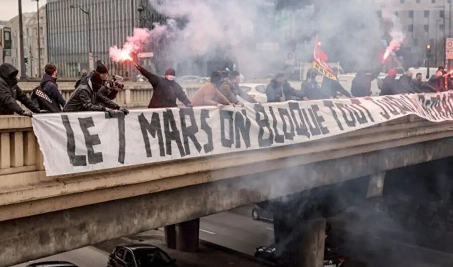 Otobüs şoförleri dün Paris'te bir üst geçitte "7 Mart'ta, (reform) geri çekilene kadar her şeyi engelleyelim" pankartıyla grev çağrısı yaptı (BBC)