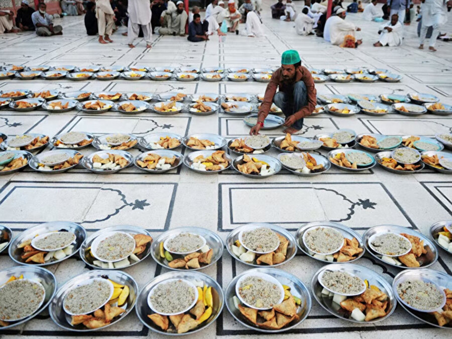 Pakistanlı Müslüman bir adam, Karaçi'de Ramazan'da oruçlarını açmadan önce Müslümanlar için iftar yemeğini düzenliyor.