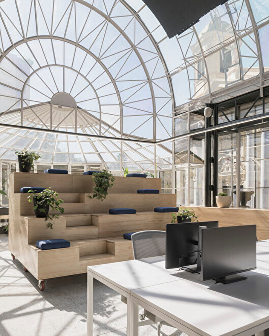 Çalışanların seçebileceği çeşitli masa ve oturma tiplerine sahip ofiste, tekerlekli basamaklı bir oturma alanı hareket ettirilebiliyor.