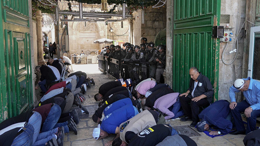 İsrail polisi "gözetiminde" namazlarını kılan Filistinliler.