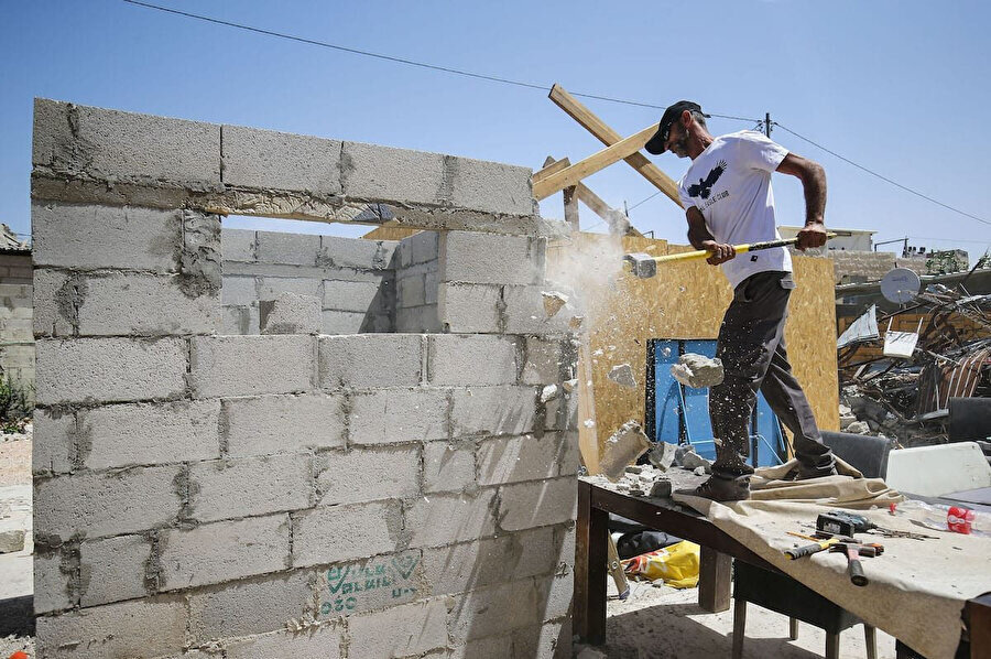 İşgal altındaki Doğu Kudüs'te yaşayan Filistinliler, İsrail'in dayattığı yıkım ücretini ödeyemeyeceği için evlerini kendi elleriyle yıkmak zorunda kalıyor.