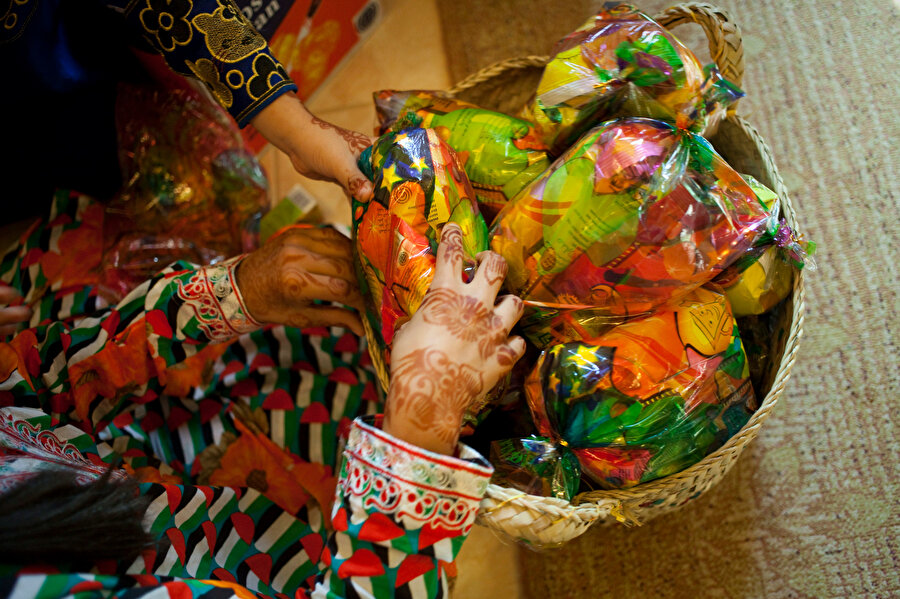 Haq Al Laila isimli geleneğe göre parlak ve renkli özel kıyafetler giyen çocuklar, sırtlarındaki çantalarla kapı kapı dolaşarak, şarkılar eşliğinde şeker ve ikram topluyor.