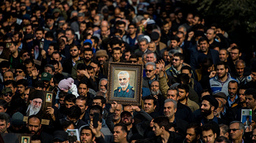 ABD tarafından öldürülen Kudüs Gücü Komutanı Kasım Süleymani ve dini lider Ali Hamaney'in fotoğraflarını taşıyan İranlılar.