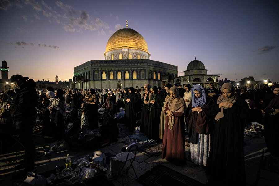 İftar vaktinin ardından sofralarını toplayan binlerce Müslüman, hep beraber namaza duruyor.