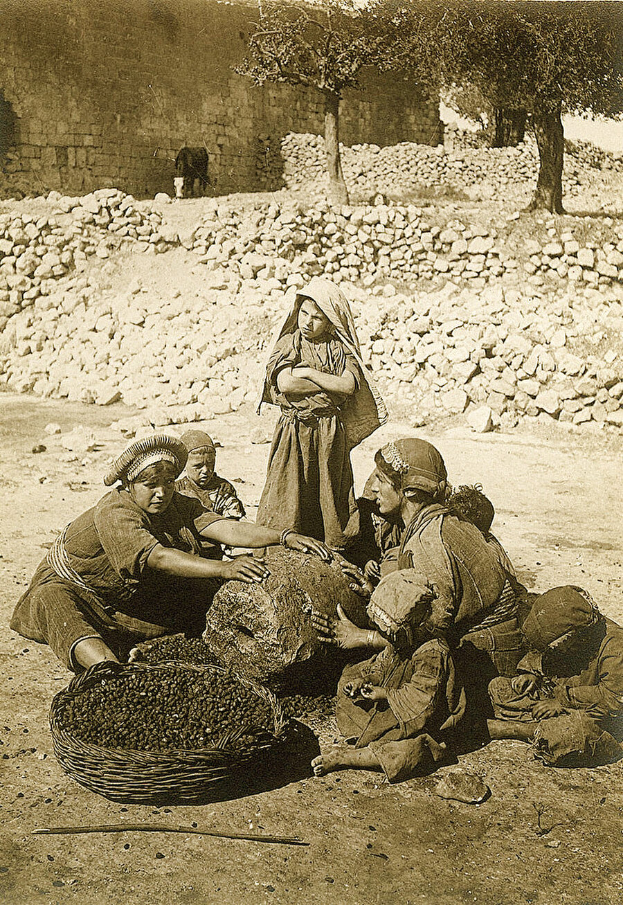 Ramallah şehrinden Filistinli kadınlar, zeytinleri ezerek zeytinyağı elde etmeye uğraşıyor.