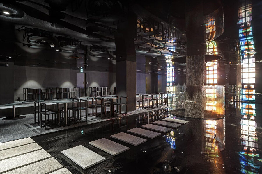 Koyu renk paletine sahip mekanlarda renkli vitraylar öne çıkıyor.
