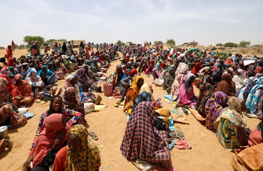 Ülkelerindeki şiddetten kaçan Sudanlı mülteciler, 9 Mayıs 2023'te Çad'ın Koufroun kentinde, Sudan ile Çad arasındaki sınırın yakınında Dünya Gıda Programından (WFP) yiyecek tayınlarını almayı bekliyorlar.