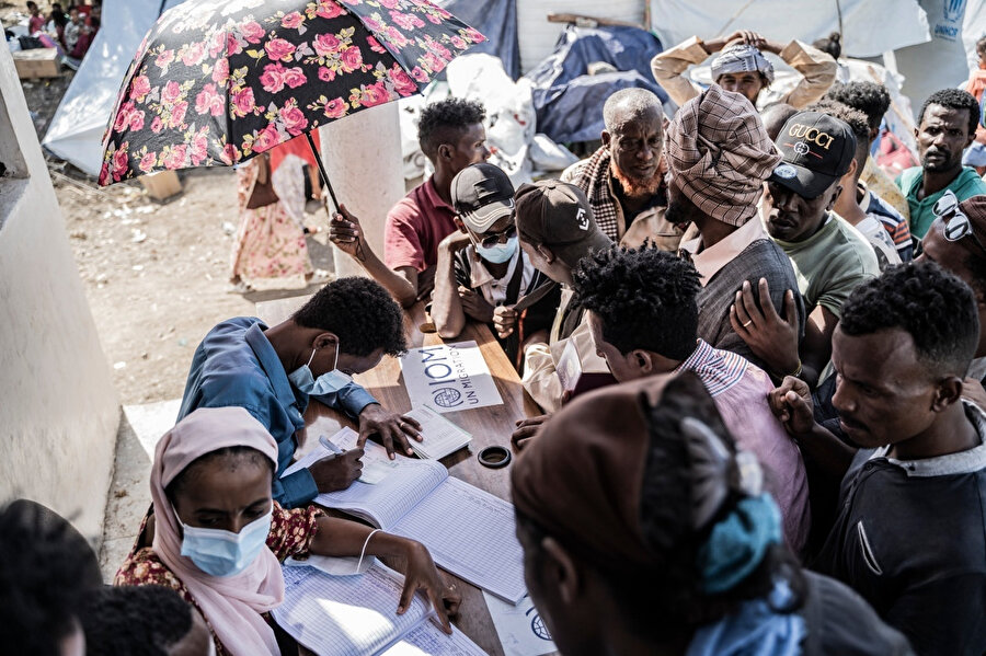 Sudan'dan Etiyopya'ya geçen mülteciler, Uluslararası Göç Örgütü'ne kaydediliyor. BM'nin Uluslararası Göç Örgütü'ne göre Nisan ortasında Hartum'da çıkan çatışmalardan bu yana 15 binden fazla kişi Metema üzerinden Sudan'dan kaçtı ve günde ortalama bin civarında giriş kaydedildi.