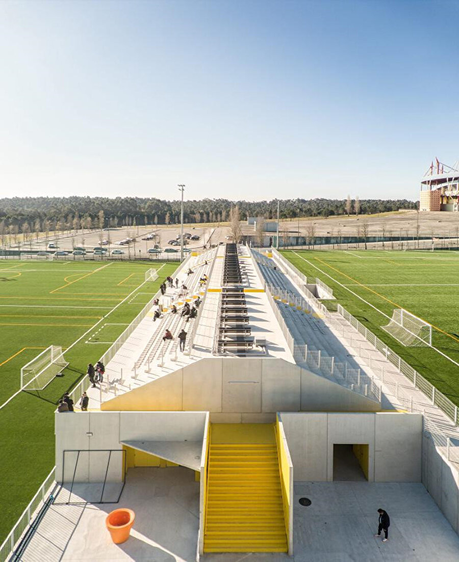 Tribünlerin uzun kenarlarında oyun alanlarına bakan yerleşim düzeni, iki futbol sahasına hizmet etmeye olanak sağlıyor.