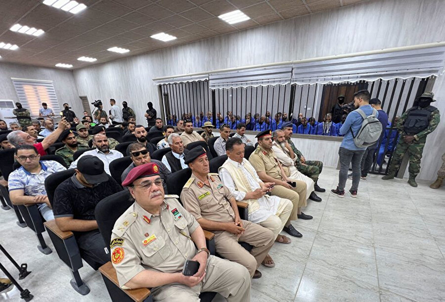Libya'nın Misrata kentindeki mahkemede Irak-Şam İslam Devleti'ne (IŞİD) katılmakla suçlanan 56 sanık, hakkında hüküm verilen karar sırasında parmaklıkların arkasında oturuyor.
