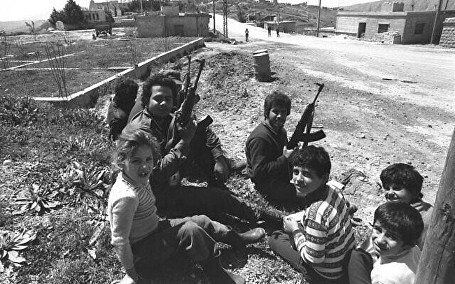 Lübnan'ın güneyindeki bir Maruni köyü olan Klea'da Falanjist askerlerle oturan çocuklar, 1 Nisan 1978.