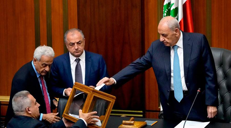 übnan Meclis Başkanı Nabih Berri, sağda, parlamento cumhurbaşkanı seçmek için toplanırken oyunu kullanıyor.