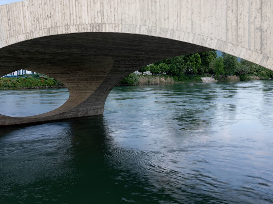 Nehir kıyısındaki yürüyüş yolunun köprüye bağlandığı yerlerde, kemerlerin altındaki geniş açıklıklar çevrenin manzarasına açılıyor. 