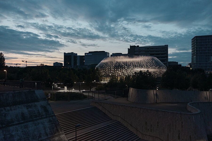 Pavyon ışıklandırılmış dairesel yapısı ile Basel'de bir sanat enstalasyonu gibi şekilleniyor. 