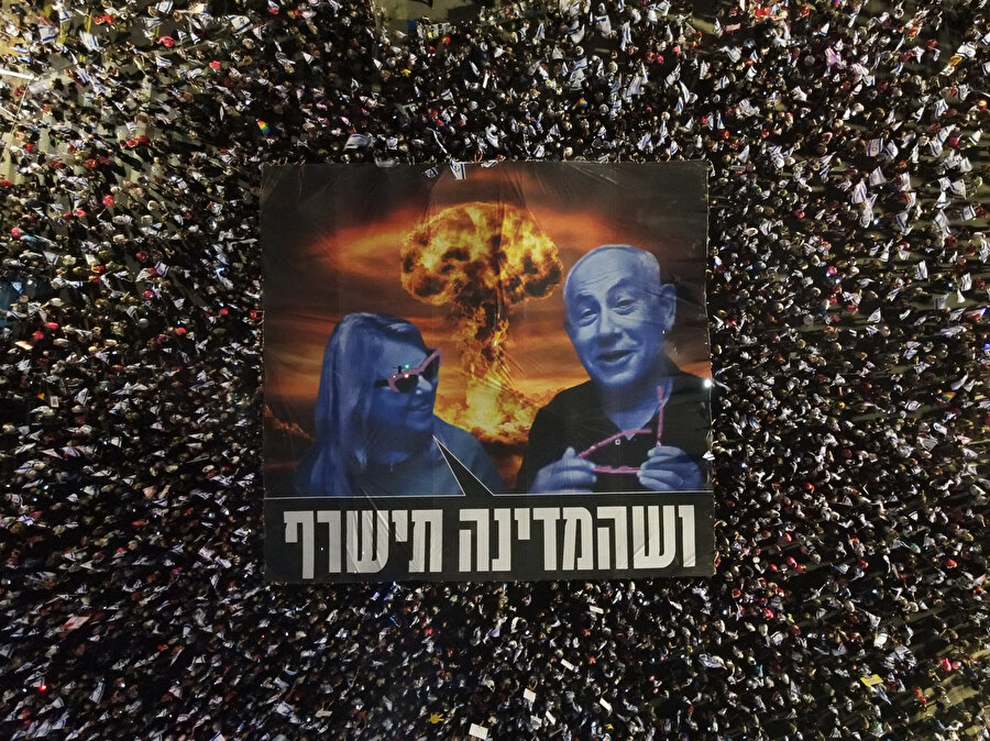 Kaplan Caddesi'nde her hafta bir ana sloganın yer aldığı dev pankart açan göstericiler, bu hafta, Başbakan Netanyahu ve eşi Sara Netanyahu’nun fotoğrafı ile birlikte 