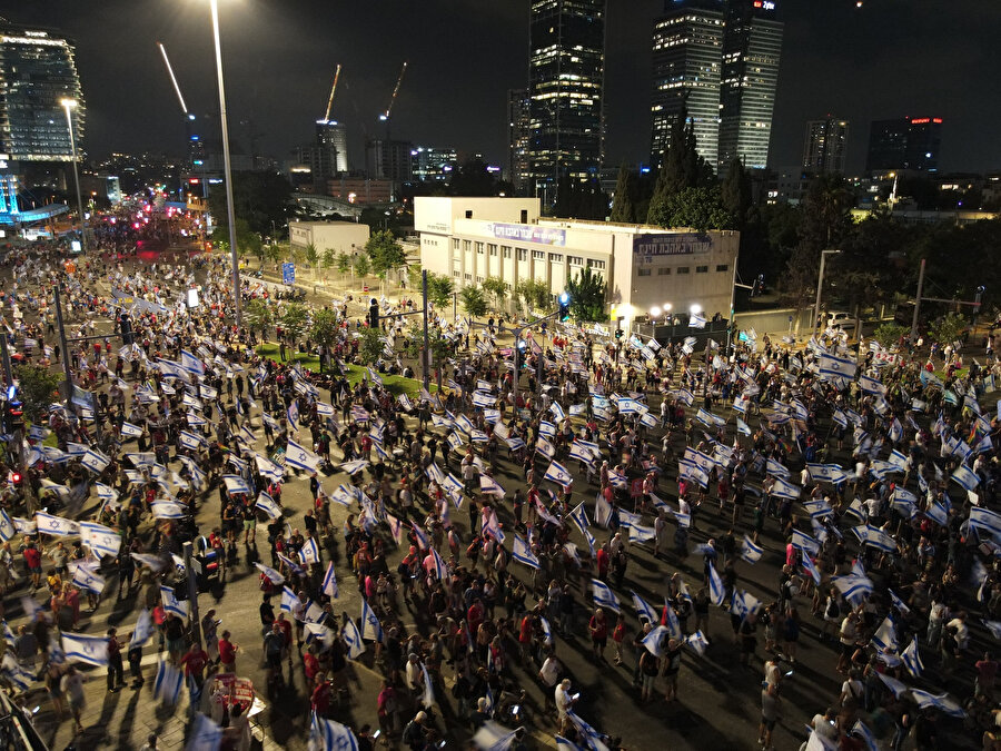 İsrail bayrakları taşıyan protestocular davullar, düdükler ve kornalarla ritim tutarak 