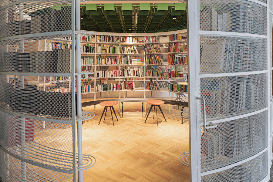 Dairesel kütüphane strüktürü yuvarlak hatlı mobilyalar ile destekleniyor. 