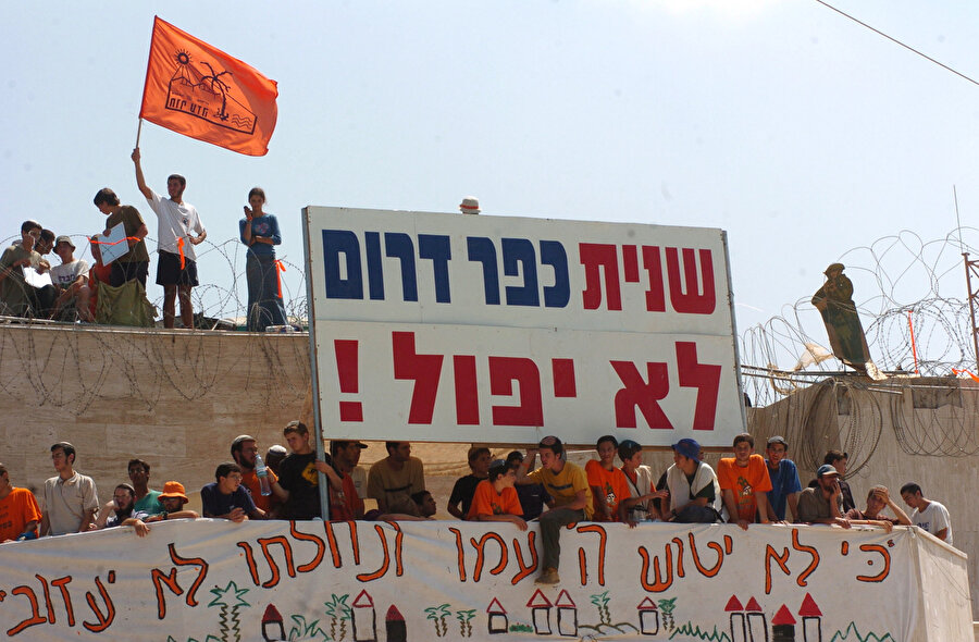 Şaron’un çekilme kararı, herkesten önce kendi halkı tarafından protesto edilmişti. (Tabelada "Kfar Darom ikinci kez düşmeyecek!" yazıyor.)