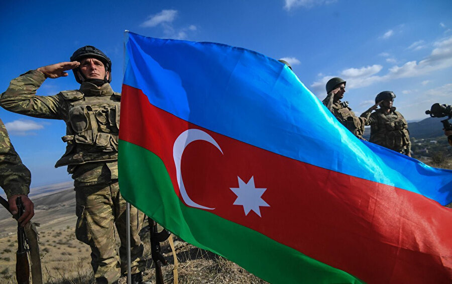 Azerbaycan ordusundan bir asker Azerbaycan bayrağıyla selam veriyor.