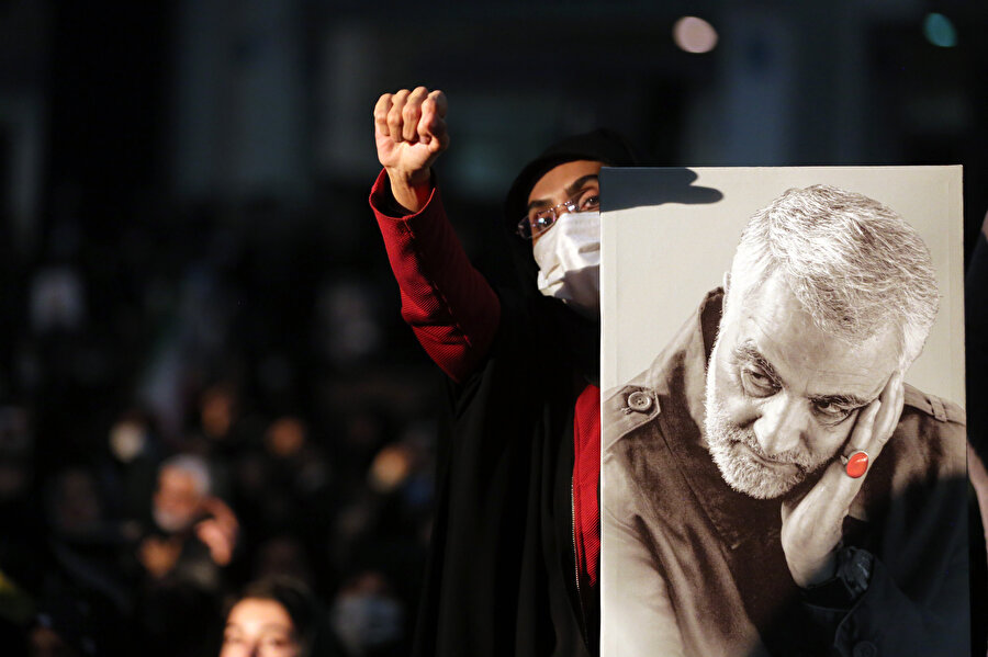 Elinde Kasım Süleymani'nin posterini taşıyan bir İranlı