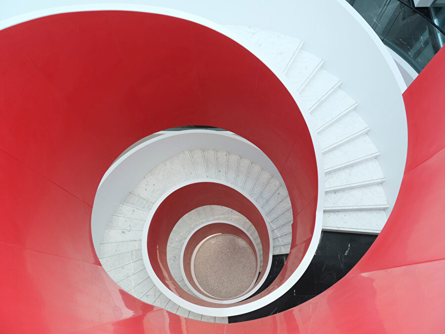 Kırmızı ve beyaz renklerin birleşimiyle temiz bir görüntü oluşturan spiral merdiven. 