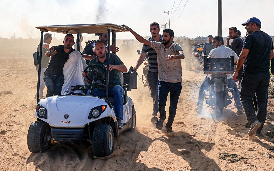 Filistinliler, Gazze Şeridi'nin güneyindeki Han Yunus'ta yakalandığı bildirilen bir İsrailli esiri götürüyor.