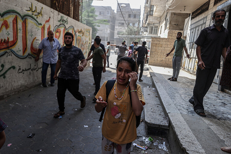 İşgalci İsrail'in saldırılarıyla koşarak evlerini terk eden Filistinliler.