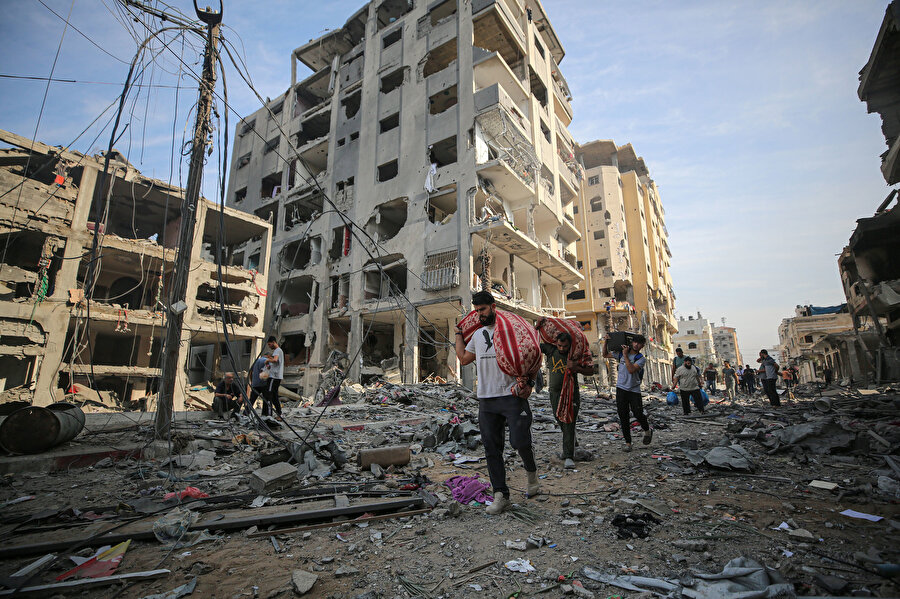 İsrail bombalarının ardından ellerine alabildikleri eşyalarla saldırı bölgesinden uzaklaşan El Karame Mahallesi'nin sakinleri.