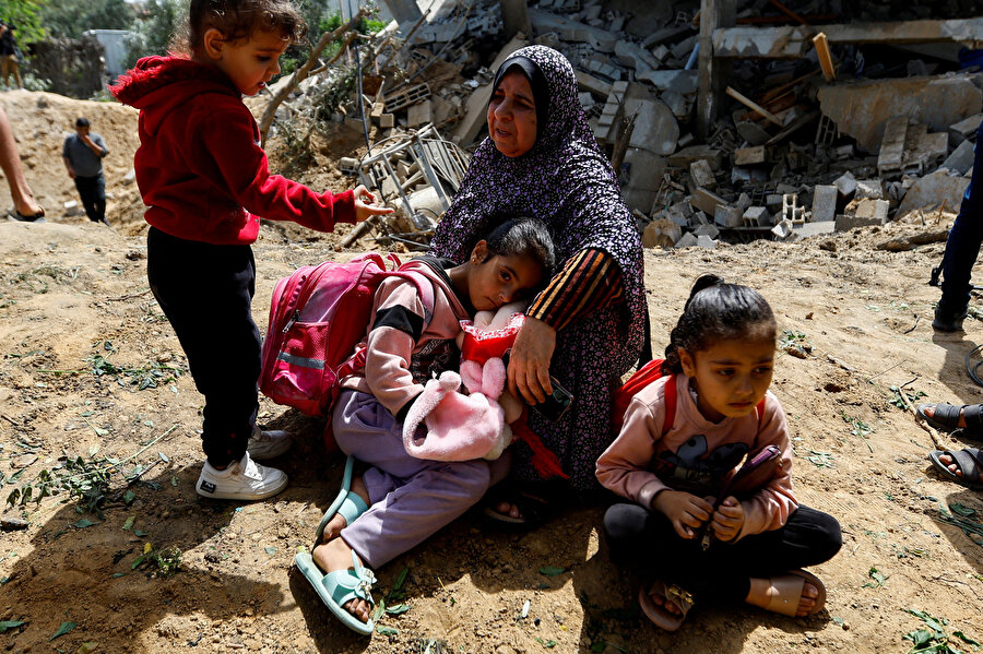 Savaş alanına dönen Gazze sokaklarında Filistinli bir aile.